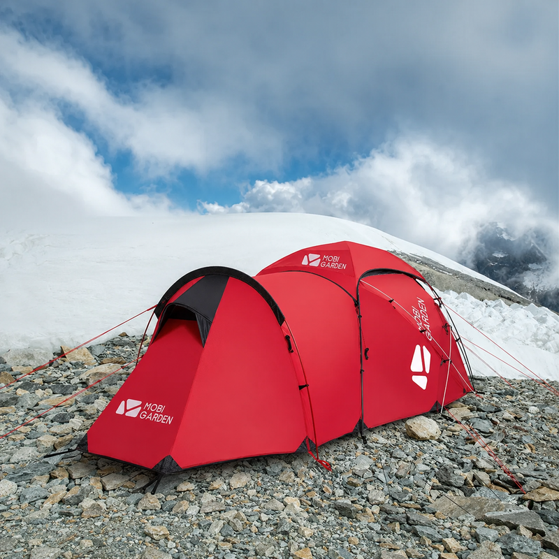 Red expedition tent secured on rocky alpine terrain